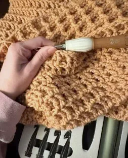 Hook working into a chunky mustard blanket
